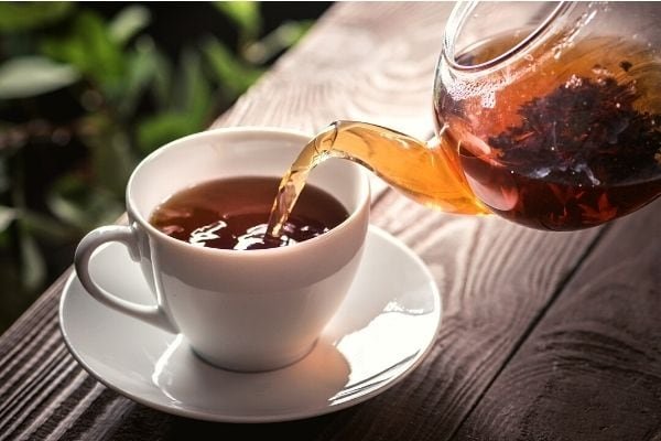 black tea being poured into a cup