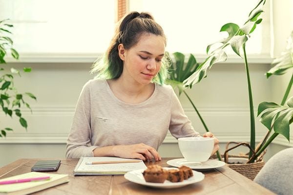 woman drinking tea while studying